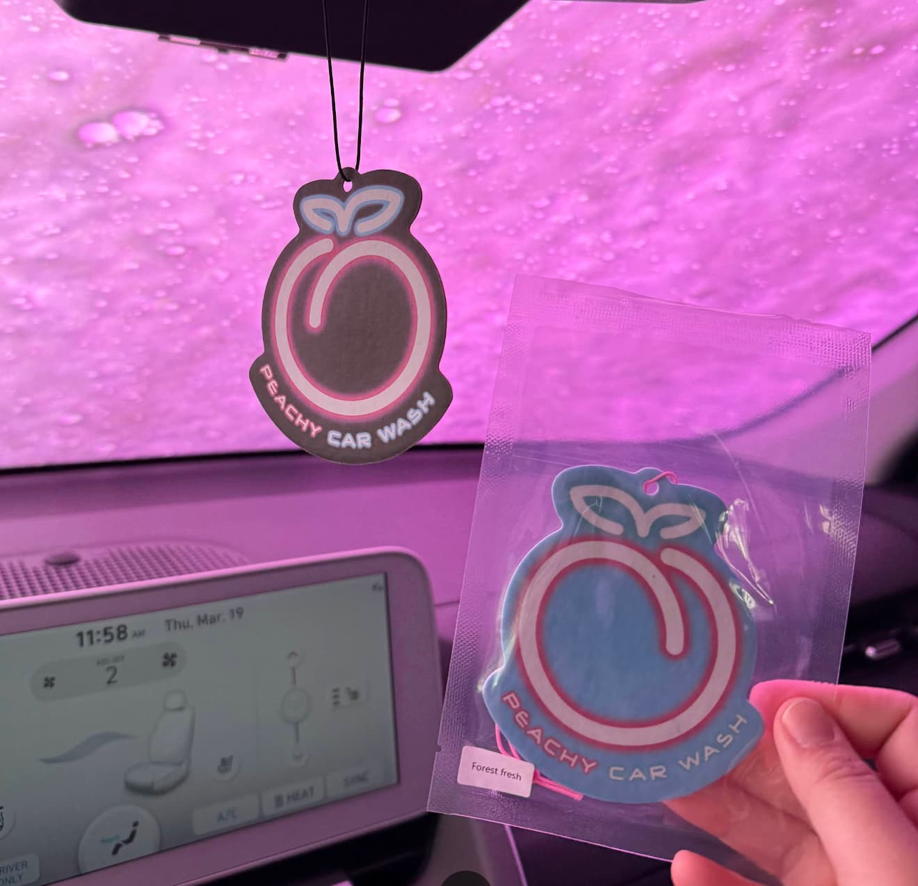 Peach-shaped Peachy Car Wash air fresheners hanging in a car